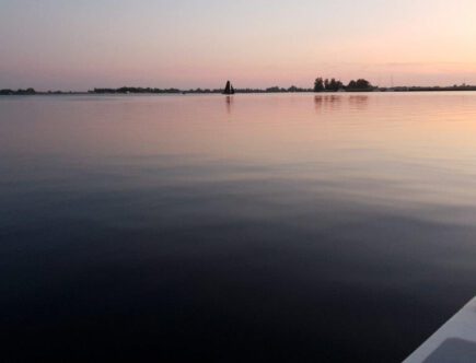 Zonsondergang tijdens het varen van de Elfstedentocht zeilboot